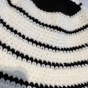 Primo piano dei dettagli del cappello a maglia a righe bianco e nero texture uncinetto.