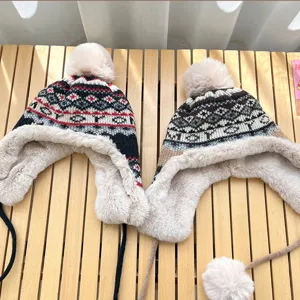 Detailed view of women winter thick warm earflap knit hat with pom pom and braided ties.