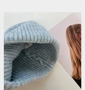 Gros plan détail du bonnet en tricot bleu clair, affichage texture côtelée hiver chaud.