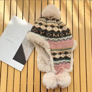 Detailed view of winter warm knit trapper hat with plush pom-pom and cozy earflaps.