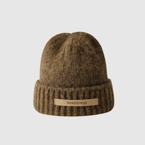 Brown knit beanie detail, warm winter woolen cap with leather patch, comfortable daily wear.