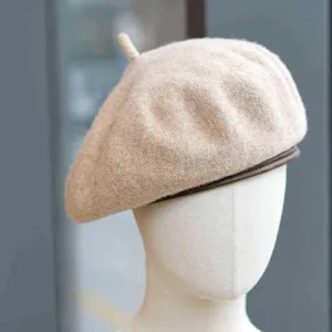 Detalle de una elegante boina de mezcla de lana con ribete de cuero, ideal para el otoño.