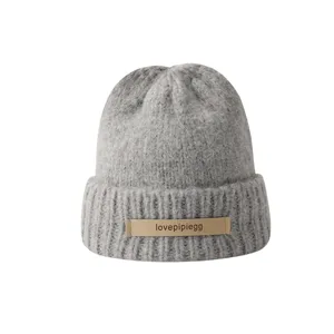 Winter warm knit beanie hat for women and men, solid color with stylish leather label.
