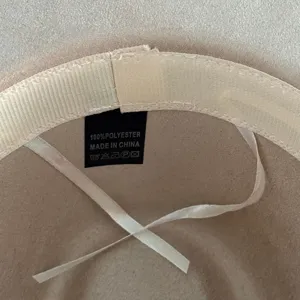 Détail intérieur du chapeau montrant des coutures soignées et une étiquette composition.