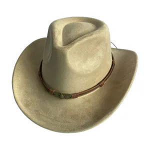 Gros plan sur le chapeau de cowboy rétro en suédine beige avec bande en cuir et tête de mort.