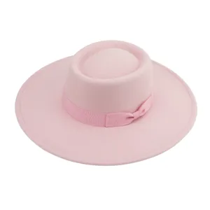 Detalle de sombrero de fieltro rosa que muestra una ala plana y un lazo elegante a juego.
