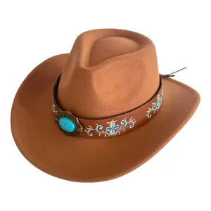 Gros plan du chapeau de cowboy en laine marron avec broderie florale bleue et boucle en pierre.