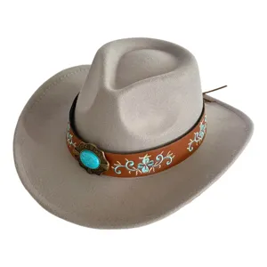 Gros plan sur un chapeau de cowboy en feutre gris avec une bande en cuir brodée et boucle.
