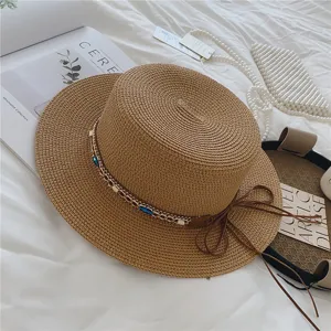 Chic summer straw hat featuring a flat top design, metal chain, and elegant bow detail.