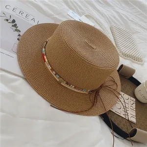 Woven straw sun hat with colorful beads and leather cord trim, ideal for beach summer travel.