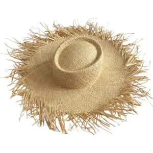 Detailed view of the wide-brim frayed raffia sun hat, perfect for summer beach and vacation styling.