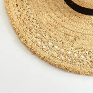 Raffia straw hat close-up, detailed woven texture, frayed edge summer beach sun hat.
