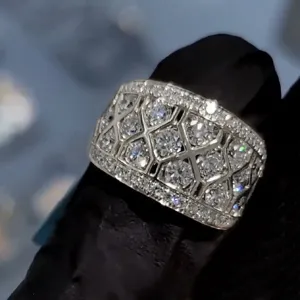 Gedetailleerde close-up van een brede geometrische ring met schitterende zirkonia.