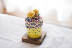 Nahaufnahme Detail von kuscheligen weichen Korallenfleece Cupcake Socken mit Pompon.