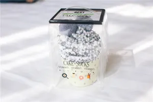 Kuschelige Korallenfleece-Flauschsocken verpackt als Cupcake-Geschenkbox für warme Füße.