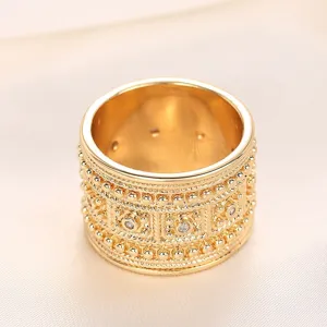 Exquisito anillo de oro de palacio con textura tallada intrincada y piedras brillantes.