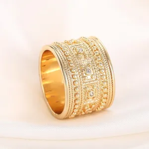 Vista detallada del anillo dorado ancho de estilo palaciego con textura de cuentas.