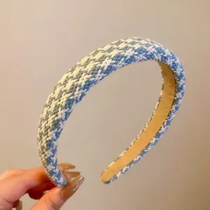Gros plan du serre-tête large en tricot bleu et blanc, montrant la texture du tissu.
