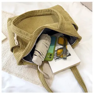 Corduroy tote bag interior detail showing spacious capacity and daily items neatly organized.