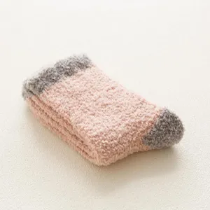 Primo piano dettagliato delle calze da notte in morbido pile corallo rosa e grigio.