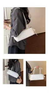 Detailed view of white star printed baguette shoulder bag with slim straps and side bows.