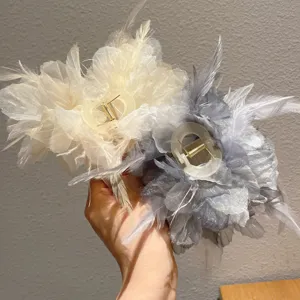 Detailed close-up showing texture and design of the elegant feather hair claw, beautiful.