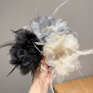 Detailed view of fluffy feather and organza hair claw clips in multiple chic colors.
