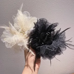 Detailed view of elegant feather and mesh hair claw clip, perfect for stylish updos.