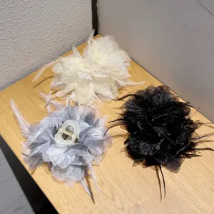 Detailed view of elegant feather hair claw clips, fluffy floral design for stylish hairstyles.