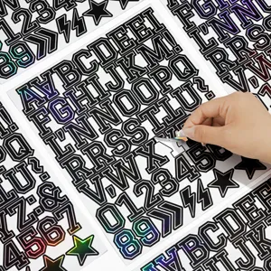 Vista di dettaglio del foglio di adesivi riflettenti olografici di lettere che mostra la rimozione.