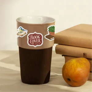 Retro book lover ceramic travel mug with cute reading stickers and brown silicone sleeve.