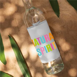 Botella de vidrio con pegatinas de alfabeto de colores, diseño elegante para decoración creativa.