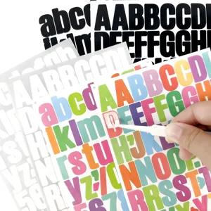 Primer plano detallado de pegatinas de letras de vinilo de colores desprendidas con pinzas.