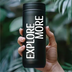 Vista detallada de una botella de agua aislada negra con un diseño de texto blanco audaz.