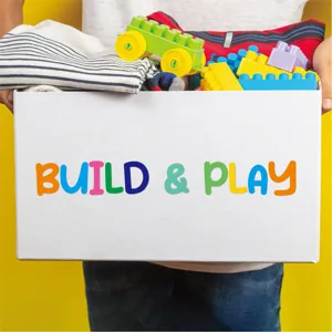 Bloques de construcción de plástico de colores y ropa doblada en una caja de almacenamiento.