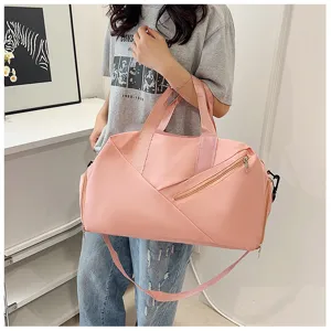 Gros plan d'un sac de voyage rose avec bandoulière et poche zippée, accessoire de sport