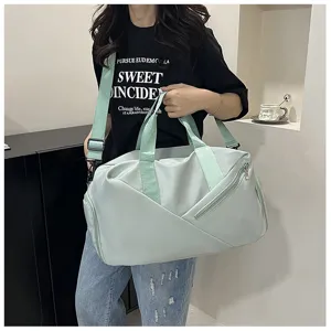 Sac de sport de voyage vert clair avec bandoulière, poche latérale et rangement étanche.