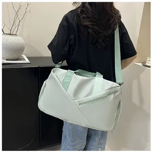 Détail du grand sac de sport vert clair montrant la bandoulière durable et la poche latérale zippée.