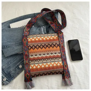 Détail du sac bandoulière tissé ethnique présentant des motifs géométriques et des franges.