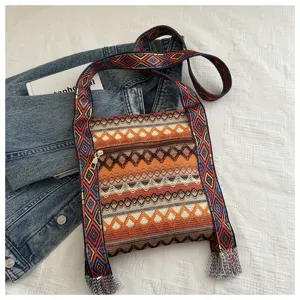 Sac a bandouliere ethnique vintage pour femme, sac a epaule elegant avec large sangle et franges.