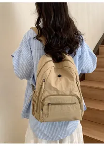 Sac à dos beige décontracté en nylon en détail, idéal pour les trajets quotidiens.