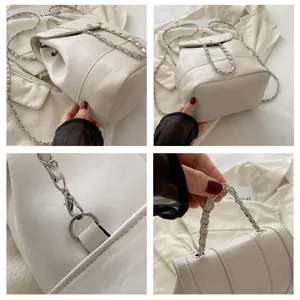 Vue détaillée d'un mini sac à dos en cuir blanc avec bretelles chaîne et bouclerie.