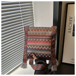 Vue rapprochée de la sangle de sac bandoulière tissée de style ethnique et des franges.