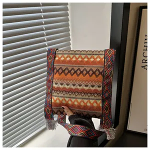 Sac à bandoulière tissé style ethnique rétro avec large sangle et franges pour femme.