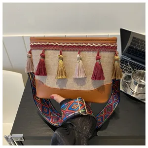 Sac à bandoulière ethnique pour femme avec pompons et sangle large colorée chic.