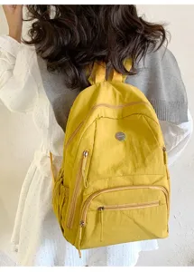 Vue détaillée du sac à dos jaune en nylon résistant, avec poches zippées pratiques pour les loisirs.