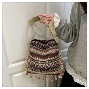 Gros plan détaillé du sac bandoulière tissé de style ethnique avec de délicates franges.