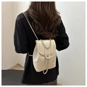 Vue rapprochée du sac à dos blanc chic avec chaîne au dos, élégant fermoir.