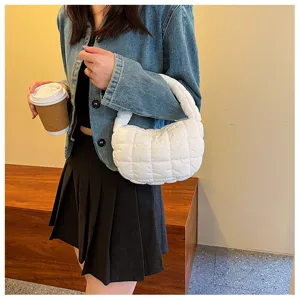 Vue rapprochée du détail du sac à main blanc matelassé élégant avec un matériau doux rembourré.