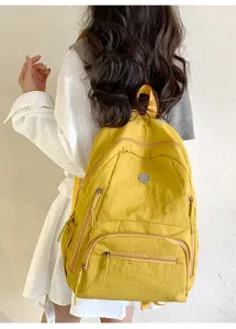 Sac à dos décontracté en nylon jaune avec poches zippées pour les voyages quotidiens.